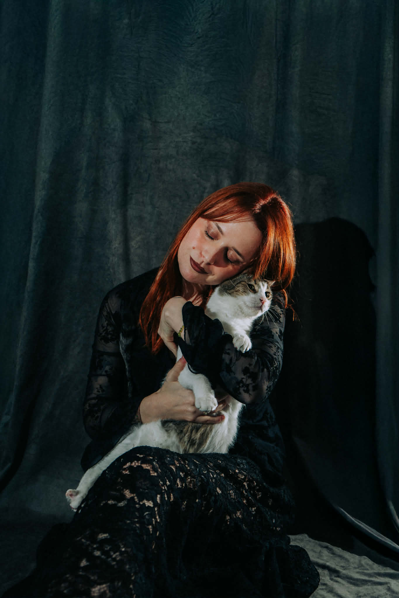 Ivy tenant un chat dans une ambiance sombre et douce